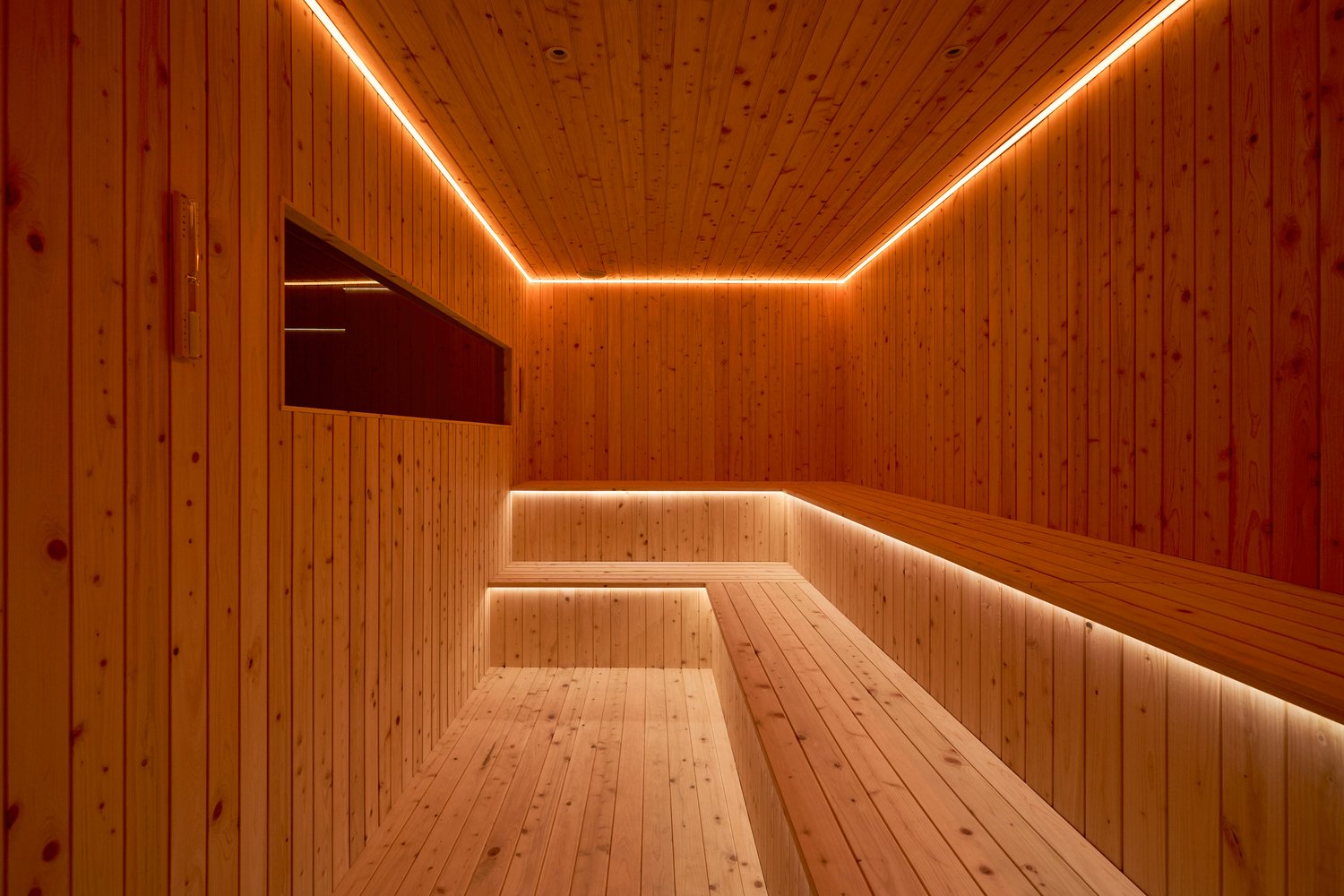 SYNC 木質桑拿室完整照片,呈現階梯座席與暖色燈光